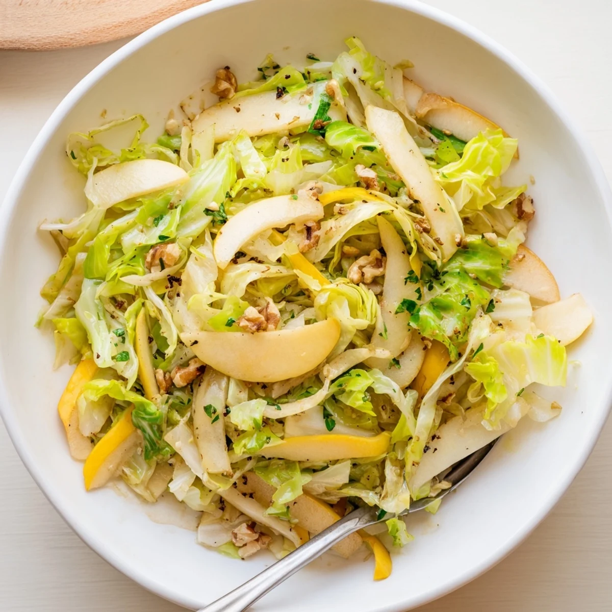 Vibrant cabbage and apple stir fry, garnished with toasted nuts for crunch.